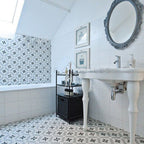 Bathroom featuring Canterbury Star Victorian-style porcelain floor and wall tiles in a 20 × 20cm format, laid in a repeating star pattern and paired with classic white sanitaryware, decorative mirrors and soft neutral tones for a timeless Victorian-inspired bathroom design.