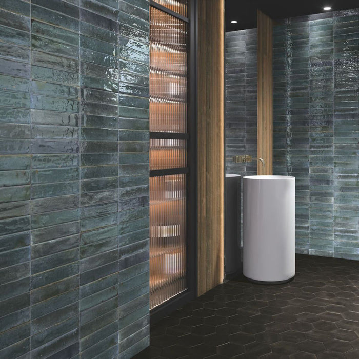 Bathroom walls featuring Allegra Blue Gloss Brick ceramic tiles in a 6 × 25cm format, laid horizontally to create a sleek, modern finish with rich blue tones and a reflective glossy surface.