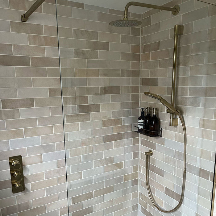 Bathroom featuring Zellige Bone Moroccan-style brick tiles in warm neutral tones, paired with brass fixtures and a compact vanity.