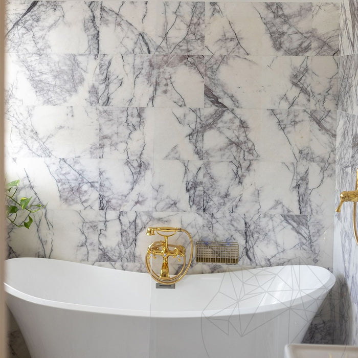 Bathroom interior featuring Fayrouz Lilac 30.5x61cm natural marble tiles with a honed finish, installed across the walls and floor to showcase a white base with soft lilac and grey veining, creating an elegant, spa-like setting with refined natural variation.