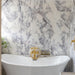 Bathroom interior featuring Fayrouz Lilac 30.5x61cm natural marble tiles with a honed finish, installed across the walls and floor to showcase a white base with soft lilac and grey veining, creating an elegant, spa-like setting with refined natural variation.