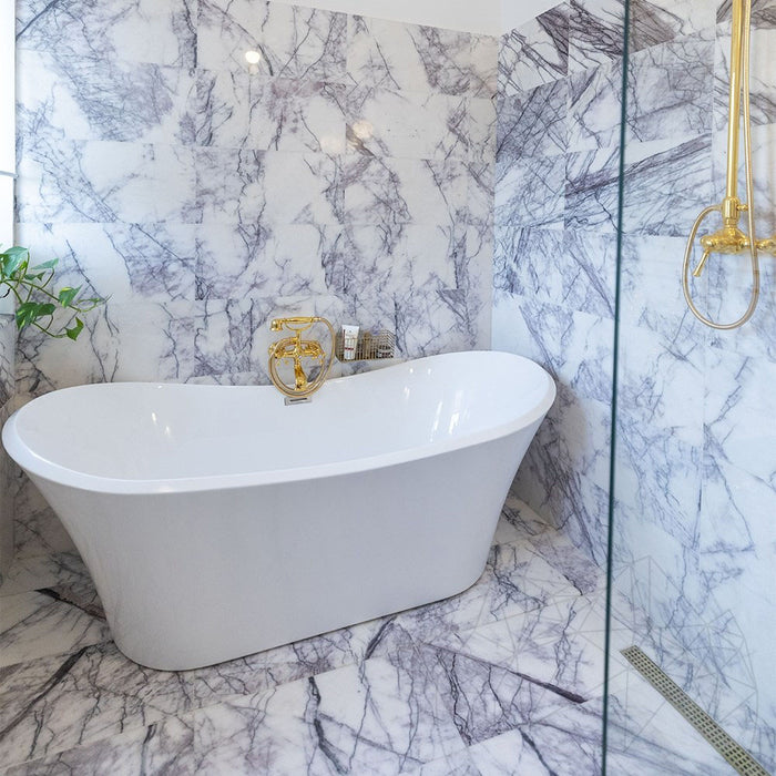 Bathroom interior featuring Fayrouz Lilac 30.5x61cm natural marble tiles with a honed finish, installed across the walls and floor to showcase a white base with soft lilac and grey veining, creating an elegant, spa-like setting with refined natural variation.