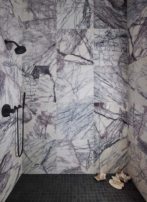 Shower interior featuring Fayrouz Lilac 30.5x61cm natural marble tiles with a honed finish, installed across the walls to showcase a white base with striking lilac and grey veining, creating a bold, immersive space with rich natural movement and variation.