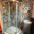 Bathroom interior featuring Fayrouz Patchwork 20×20cm Moroccan-style porcelain wall tiles, showcasing a vibrant mix of colourful geometric and floral patterns arranged in a bold patchwork design.