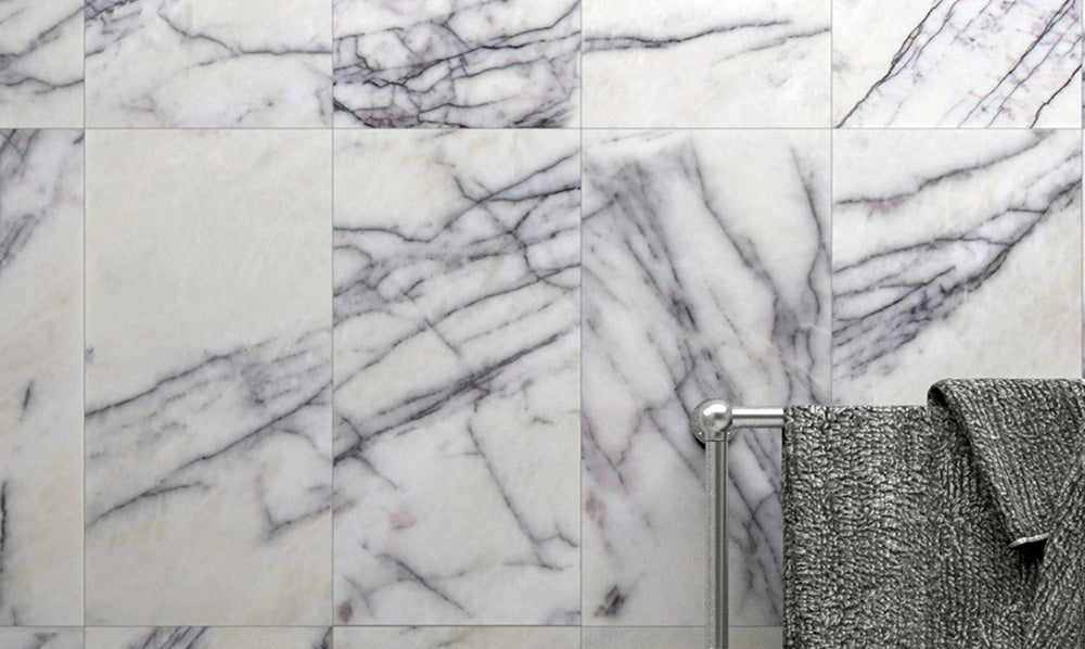 Bathroom wall featuring Fayrouz Lilac 30.5x61cm natural marble tiles with a honed finish, showcasing a soft white base with delicate lilac and grey veining, creating a calm, elegant surface with natural variation and a refined, timeless feel.