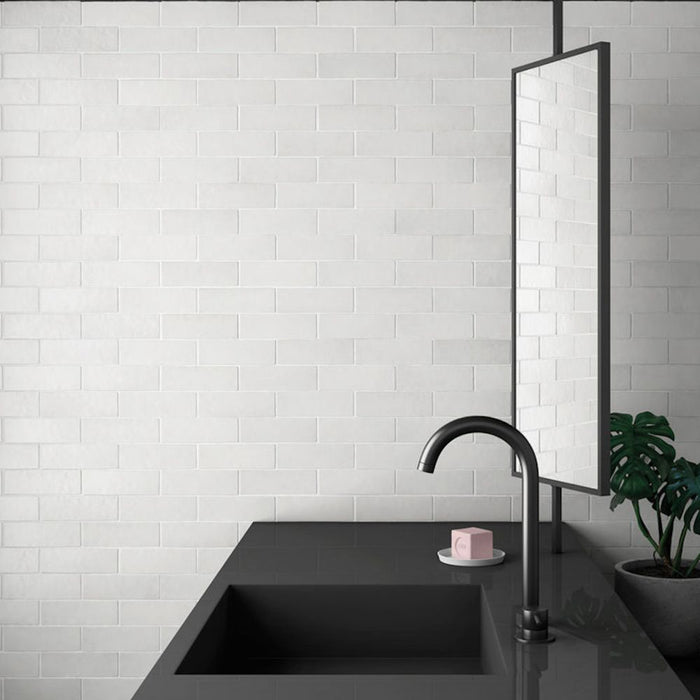 Bathroom wall featuring Zellige Chalk White Moroccan-style brick tiles in a 6.5 × 20cm format, paired with a matte black basin and mirror.