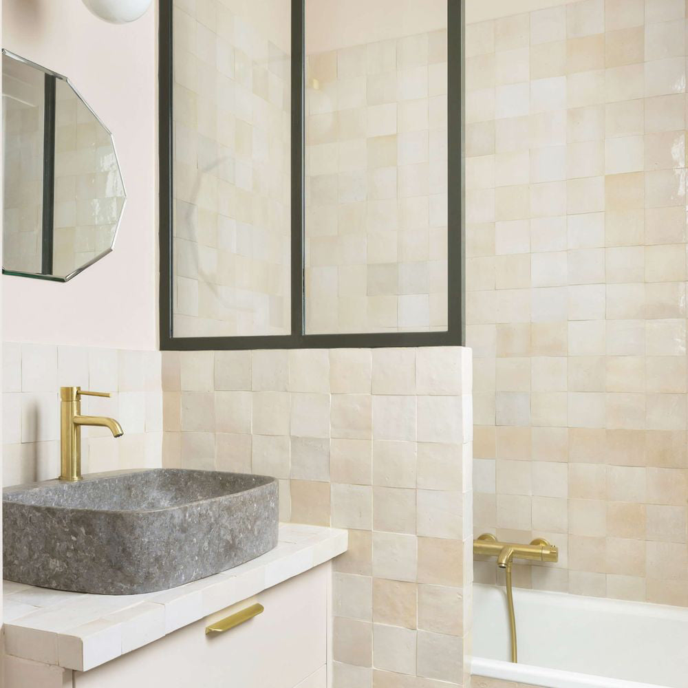Bathroom featuring Zellige Bone Moroccan-style square tiles in soft neutral tones, paired with brass fittings and a stone basin.