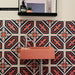 Bathroom interior featuring London Streets Conduit Street 20x20cm Victorian Moroccan style wall tiles, styled with a pink basin sink, chrome tap and black mirror shelf, creating a bold patterned bathroom feature wall.