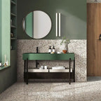 Bathroom featuring Turin Terrazzo Blanco Drops porcelain tiles in a 20 × 20cm format, displaying a light terrazzo-style design with fine scattered stone fragments, used across the floor and lower wall and paired with green cabinetry, black fixtures and warm wood accents for a calm, contemporary look.
