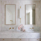 Benomar White Moroccan Mini Brick Gloss Tile 5x15cm used in a vertical stacked layout, featuring crisp white gloss tiles with subtle surface variation, styled in a contemporary bathroom with marble vanity and brass fixtures.