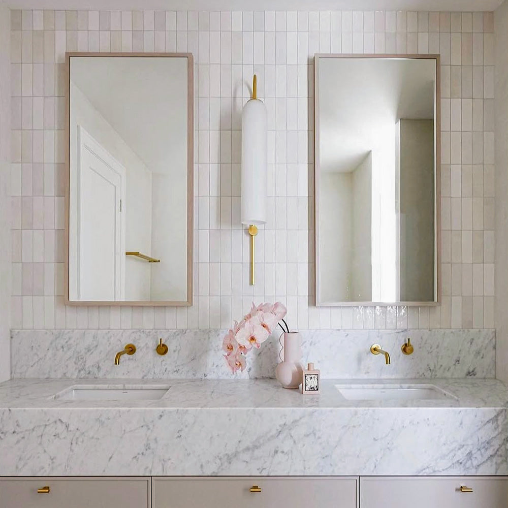 Benomar White Moroccan Mini Brick Gloss Tile 5x15cm used in a vertical stacked layout, featuring crisp white gloss tiles with subtle surface variation, styled in a contemporary bathroom with marble vanity and brass fixtures.