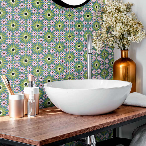 Bathroom vanity splashback featuring Fez Mini Summer 15x15cm Moroccan-style porcelain tiles, showcasing a colourful geometric star pattern in soft green, blue and blush pink tones, styled with a white countertop basin, warm wood worktop and copper accessories for a bright, characterful finish.