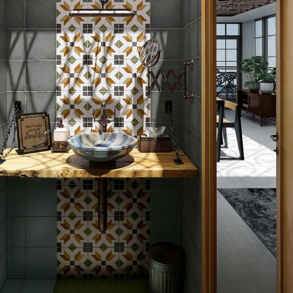Victorian-style bathroom featuring Viscount High Street 20×20cm porcelain wall and floor tiles with a geometric pattern in olive green, mustard and charcoal tones, styled as a statement splashback behind a ceramic basin with a rustic wooden countertop, vintage-style fittings and dark green wall tiles.