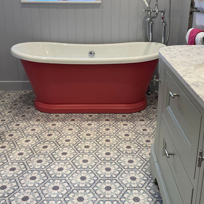 Bathroom featuring Medina Frost Blue Moroccan-style hexagon porcelain floor tiles, 18.7 × 21.6 cm, laid in a repeating geometric pattern and paired with a freestanding bath and classic cabinetry.