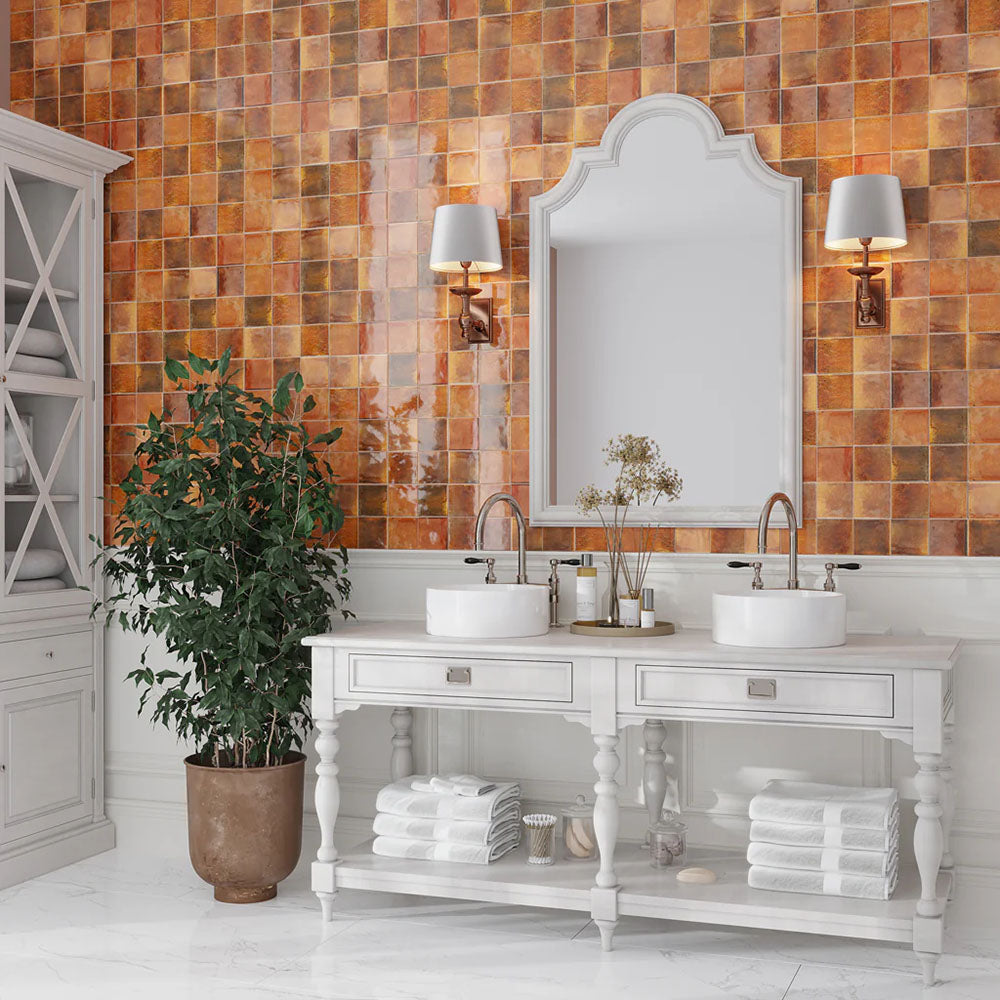 Bathroom featuring Saigon Amber Square Wall tiles in a Moroccan-inspired style, 10 × 10cm glossy ceramic tiles in warm amber tones, paired with a white double vanity and classic wall lighting.