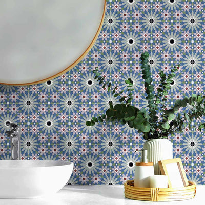 Bathroom vanity splashback featuring Fez Mini Artisan 15x15cm Moroccan-style porcelain tiles, showcasing a detailed multicolour geometric pattern in soft blue, blush pink, green and terracotta tones, styled with a round mirror, ceramic basin and natural accessories for a calm, decorative finish.