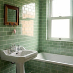 Bathroom featuring Pimlico Lime Green 7.5 × 15cm ceramic wall tiles with a crackle glaze finish, laid in a classic brick pattern around the bath and basin for a fresh, vintage-inspired look.