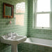 Bathroom featuring Pimlico Lime Green 7.5 × 15cm ceramic wall tiles with a crackle glaze finish, laid in a classic brick pattern around the bath and basin for a fresh, vintage-inspired look.