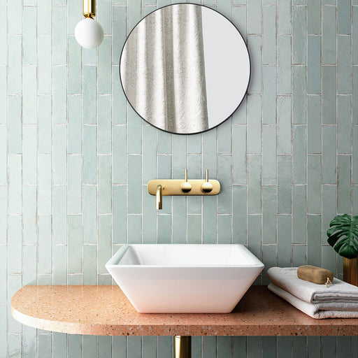 Bathroom featuring Nomad Mint Green brick wall tiles in a 6 × 24.6cm format, laid vertically behind a countertop basin for a fresh, contemporary look.