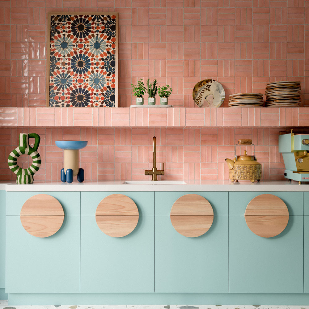 Kitchen featuring Benomar Pink Gloss 5x15cm Moroccan-style wall tiles in a geometric layout, styled with pastel blue cabinetry, brass fixtures, and decorative accents for a playful contemporary interior.
