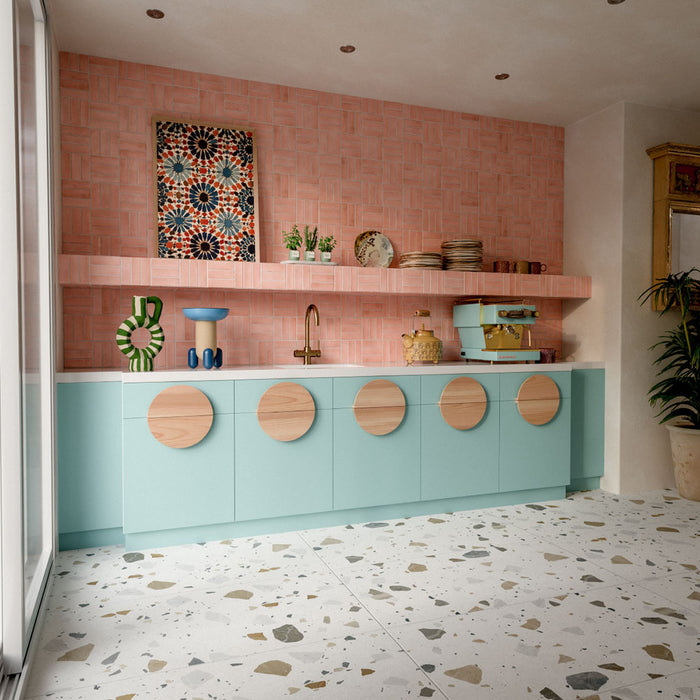 Kitchen featuring Benomar Pink Gloss 5x15cm Moroccan-style wall tiles in a geometric layout, styled with pastel blue cabinetry, brass fixtures, and decorative accents for a playful contemporary interior.