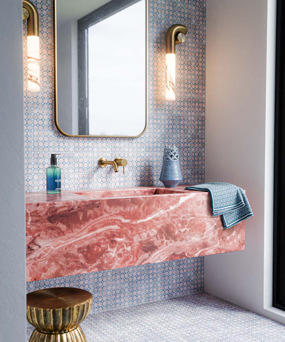 Berber Mequinez Blue 15cm x 15cm Moroccan style tiles, showcasing a delicate blue geometric pattern on a soft pink background across the bathroom wall and floor, complemented by a bold pink marble vanity and brass fittings.
