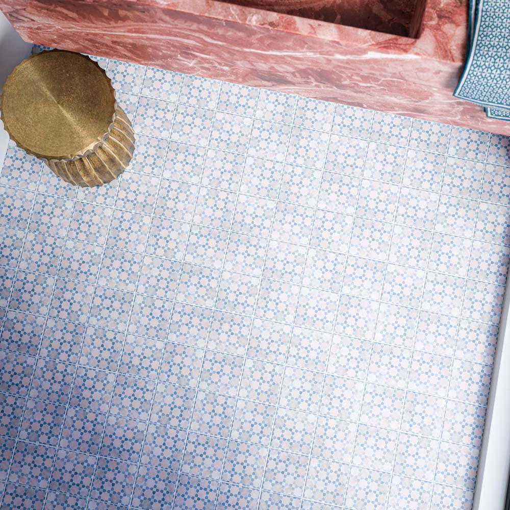 Berber Mequinez Blue 15cm x 15cm Moroccan style tiles, featuring a delicate repeating geometric pattern in blue and soft pink across the bathroom floor, paired with a statement pink marble vanity and brass details.