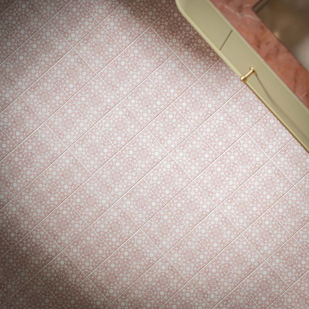 Berber Tetuan Rose 15cm x 15cm Moroccan style floor tiles, showcasing an intricate repeating geometric pattern in soft pink and white, paired with cream cabinetry and warm brass details.