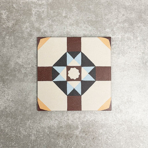 Single London Streets Berlin Street 20x20cm Victorian Moroccan style porcelain tile displayed in a product setting, featuring a geometric star pattern in burgundy, soft blue, charcoal and cream tones inspired by traditional decorative floor tiles.