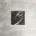 Single Fayrouz Black 15.2x15.2cm natural marble tile with a honed finish, featuring deep black tones and bold white veining, displayed against a neutral textured background in a clean product setting.