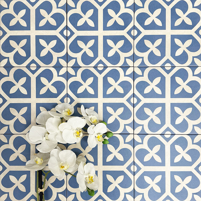 Ivy Blue Victorian Moroccan style 20x20cm patterned tiles, shown in a flat lay with decorative flowers highlighting the blue and white geometric design.