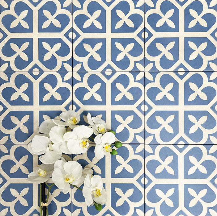 Ivy Blue Victorian Moroccan style 20x20cm patterned tiles, shown in a flat lay with decorative flowers highlighting the blue and white geometric design.