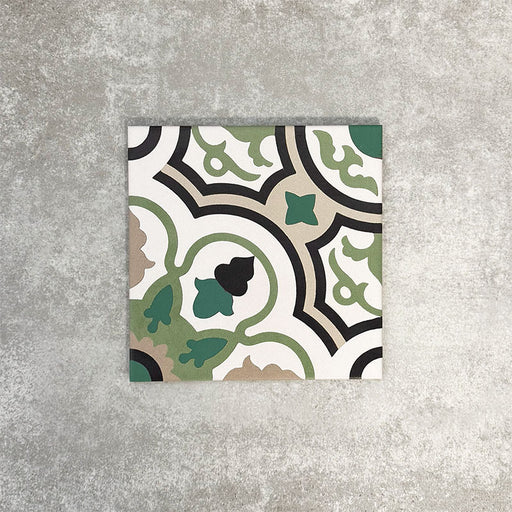 Single London Streets Bond Street 20x20cm Victorian Moroccan style porcelain tile displayed in a product setting, featuring a decorative geometric pattern in green, black, beige and cream tones inspired by traditional Victorian style floor tiles.