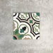 Single London Streets Bond Street 20x20cm Victorian Moroccan style porcelain tile displayed in a product setting, featuring a decorative geometric pattern in green, black, beige and cream tones inspired by traditional Victorian style floor tiles.