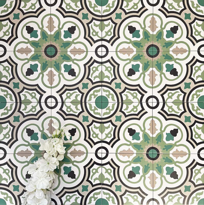 Group of London Streets Bond Street 20x20cm Victorian Moroccan style porcelain tiles arranged to showcase the repeating geometric pattern in green, black and cream tones, styled with white flowers in a decorative flat-lay setting.