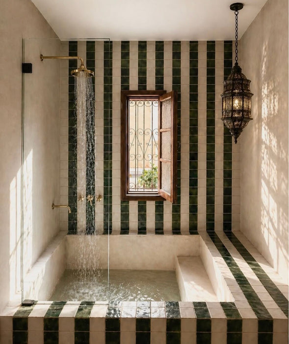 Moroccan style bathroom featuring Bora Bora White Sand Square 10cm x 10cm wall tiles, paired with deep green square tiles in a striped design around a sunken bath and shower area.