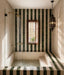 Moroccan style bathroom featuring Bora Bora White Sand Square 10cm x 10cm wall tiles, paired with deep green square tiles in a striped design around a sunken bath and shower area.