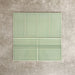 Pimlico Lime Green 7.5 × 15cm ceramic wall tiles with a crackle glaze finish, paired with matching 15 × 15cm skirting tiles to create a classic brick layout with a decorative base detail.