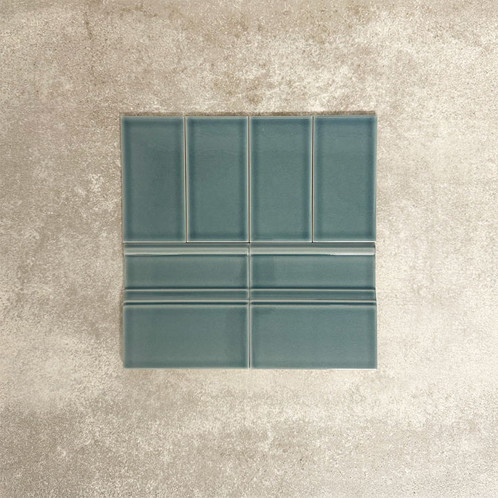 Pimlico River Blue 7.5 × 15cm ceramic wall tiles with a crackle glaze finish, paired with matching 15 × 15cm skirting tiles to create a classic brick layout with a decorative base detail.