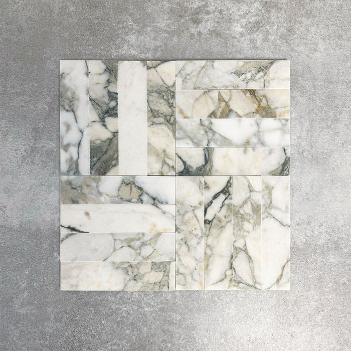 Arrangement featuring Fayrouz Calacatta Green 5x20cm natural marble tiles with a honed finish, laid in a basketweave pattern combining horizontal and vertical pieces to create visual movement, highlighting the bold green and gold veining against a soft white marble base.