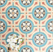 Group of London Streets Carnegie Hall 20x20cm Victorian Moroccan style porcelain tiles arranged together to showcase the repeating geometric pattern in teal, cream, terracotta and black tones, styled with white flowers for a decorative flat-lay setting.