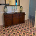 Hallway featuring Chatsworth Manor Victorian style 20cm x 20cm patterned floor tiles in red, blue, cream and black, paired with antique wooden furniture, decorative ceramics and traditional interior details.