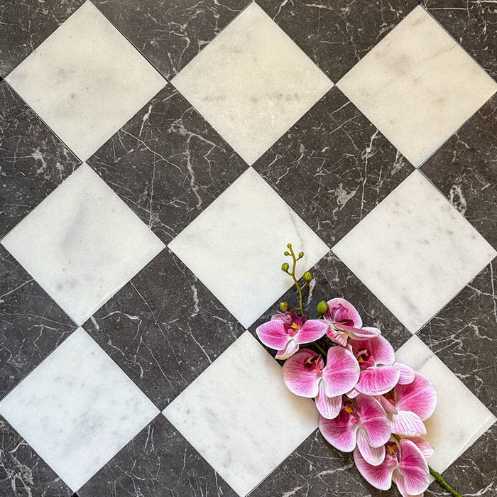 Chequerboard layout featuring Fayrouz White 15.2x15.2cm natural marble tiles with a honed finish, paired with black marble tiles, installed diagonally and styled with pink orchid flowers for a soft decorative contrast.