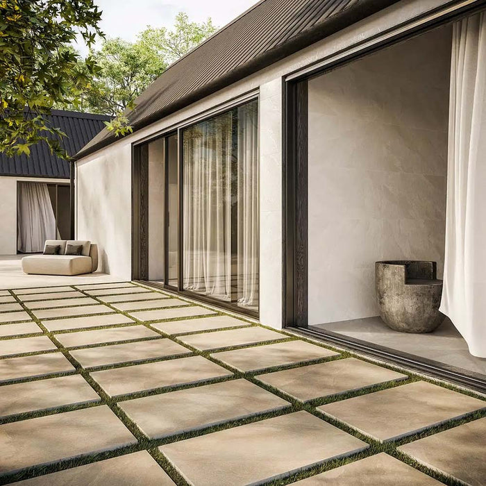 Outdoor patio featuring Comet Light Stone 2cm 60 × 90cm porcelain tiles, laid with grass joints to soften the layout. Soft beige stone effect tones and subtle variation create a calm, contemporary outdoor space.