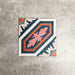 Single London Streets Conduit Street 20x20cm Victorian Moroccan style porcelain tile displayed in a product setting, featuring a bold geometric pattern in pink, teal and terracotta tones inspired by traditional decorative Victorian floor tiles.
