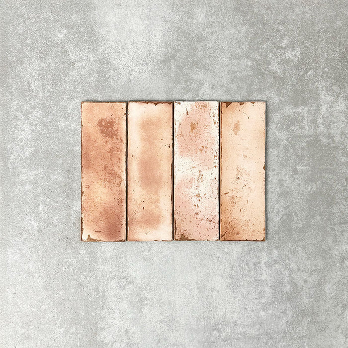 Close-up of Foundry Bricks Coral Pink 6.5x20cm brick wall tiles, showcasing warm blush and terracotta tones with subtle tonal variation, lightly textured surface and gently irregular edges for a refined, contemporary finish.