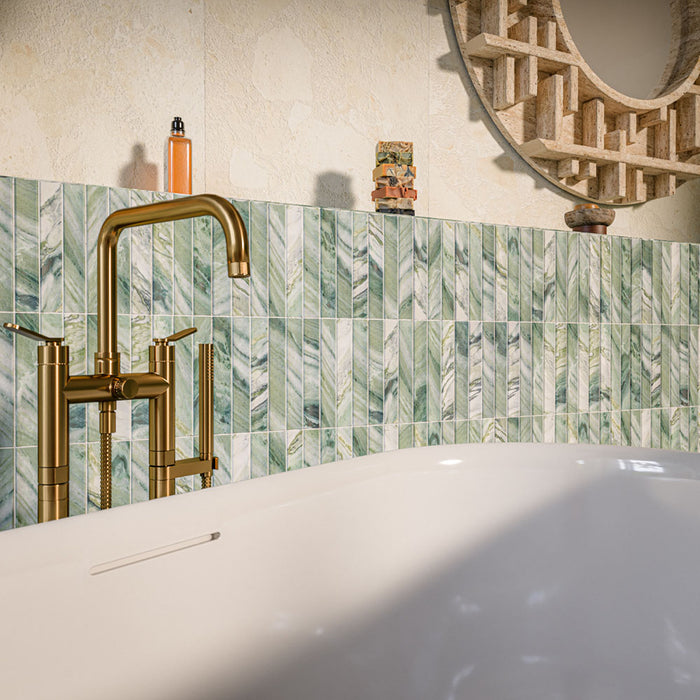 Crete Fluted Jade 11.5cm x 23cm matt wall tiles, featuring varied green and white marble effect tones in a geometric layout behind a freestanding bath, paired with warm brass fittings.