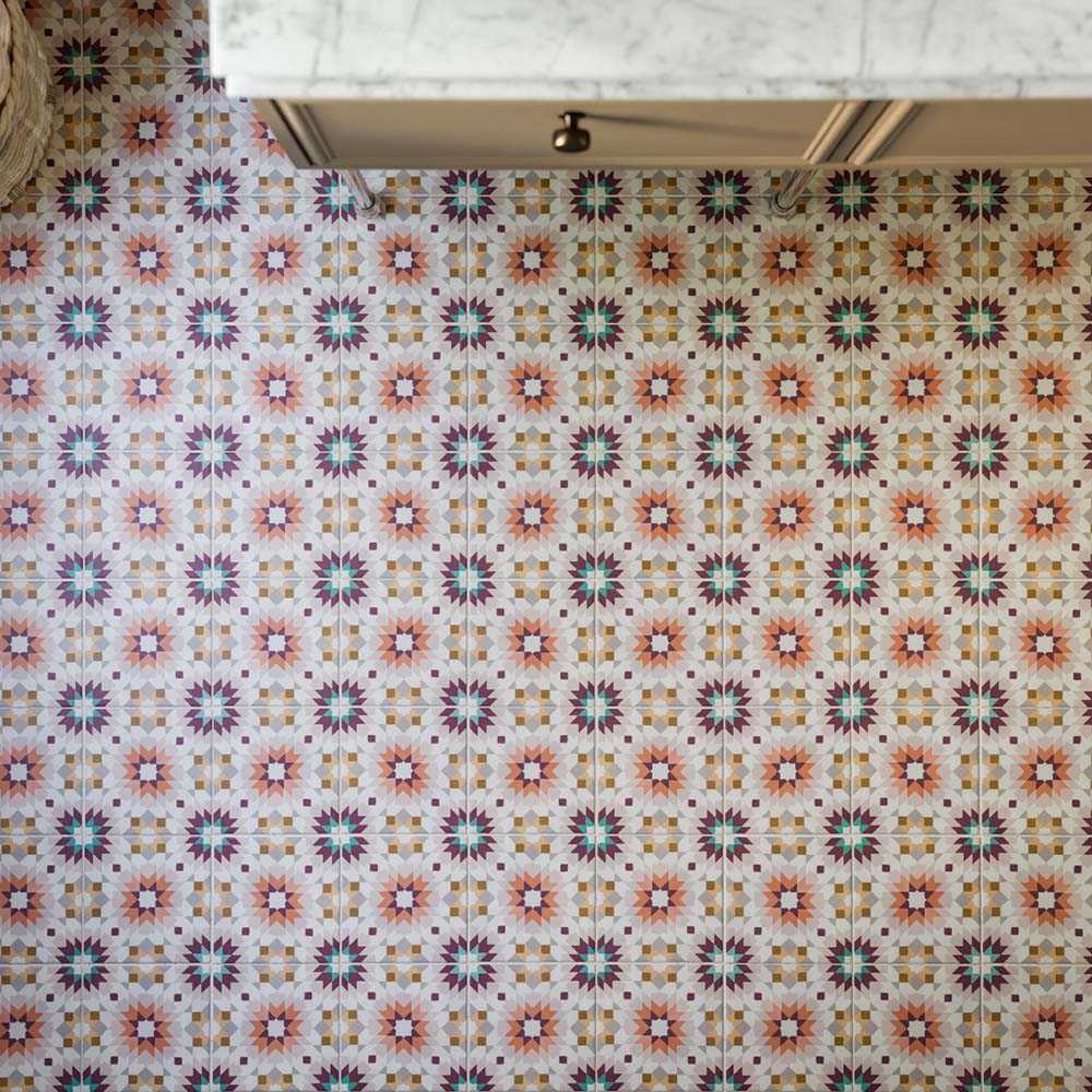 Floor featuring Cuba Manzanillo 20cm x 20cm Moroccan style patterned tiles, showcasing an intricate geometric design in pink, green, burgundy and warm neutral tones, creating a colourful statement beneath classic cabinetry.