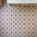 Floor featuring Cuba Manzanillo 20cm x 20cm Moroccan style patterned tiles, showcasing an intricate geometric design in pink, green, burgundy and warm neutral tones, creating a colourful statement beneath classic cabinetry.