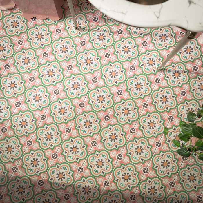 Close-up of Cuba Paradise 20x20cm Moroccan-style patterned bathroom floor tiles, featuring pink backgrounds, green and cream floral motifs and warm terracotta accents, arranged in a repeating decorative design.